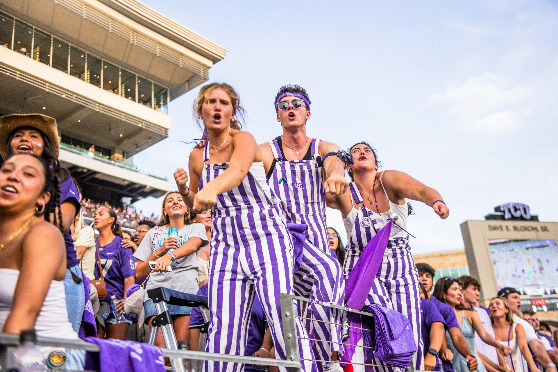 TCU fans in striped overalls cheering